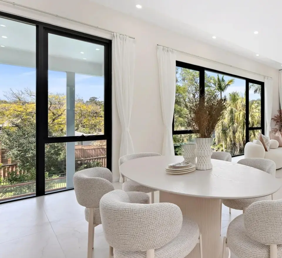 Dining room framed by black aluminium fixed and awning windows