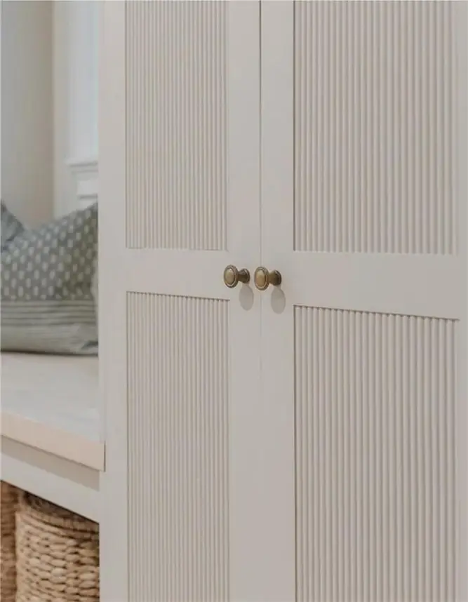 Fluted painted cabinet doors with brass knobs