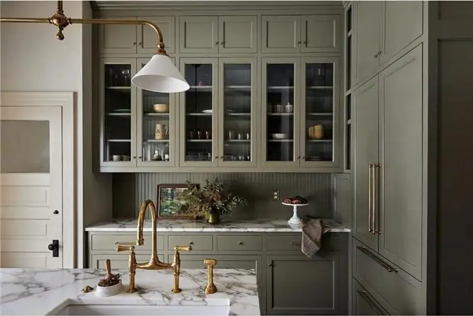 Sage green shaker kitchen with glazed upper cabinets